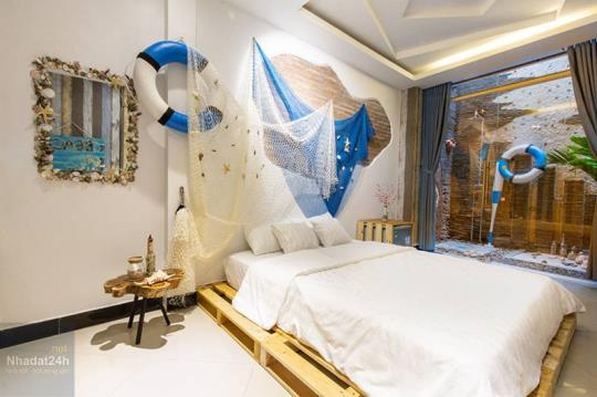 Phòng ngủ được trang trí mang đậm phong cách của biển với lưới đánh cá, phao bơi